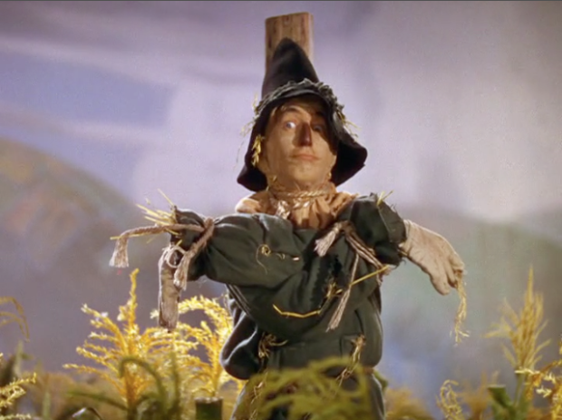 Scarecrow from original Wizard of Oz film with arms crossed.